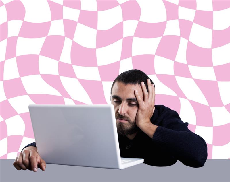Man resting head on hand while staring at laptop against pink patterned background, expressing boredom, fatigue, or work burnout.