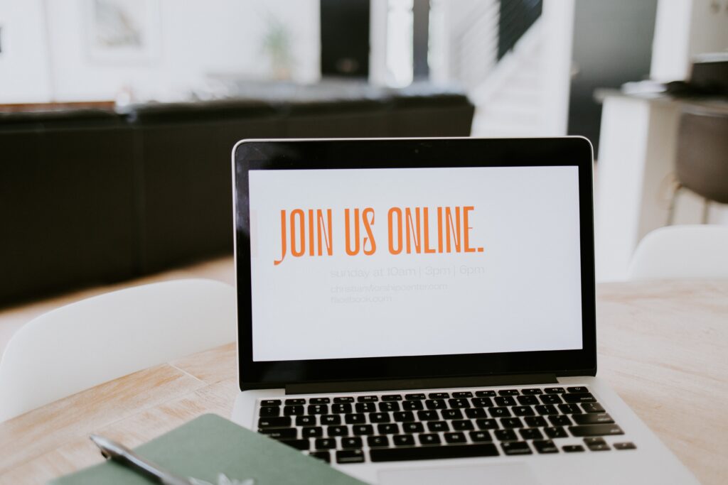 Laptop on a table displaying “Join Us Online” promoting virtual events or online participation.