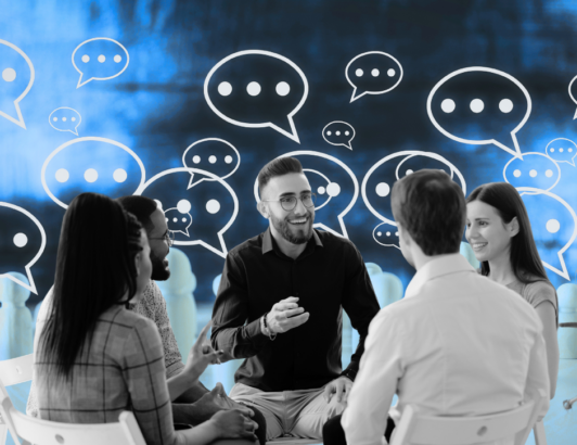 Employees sitting at a table, smiling and talking.