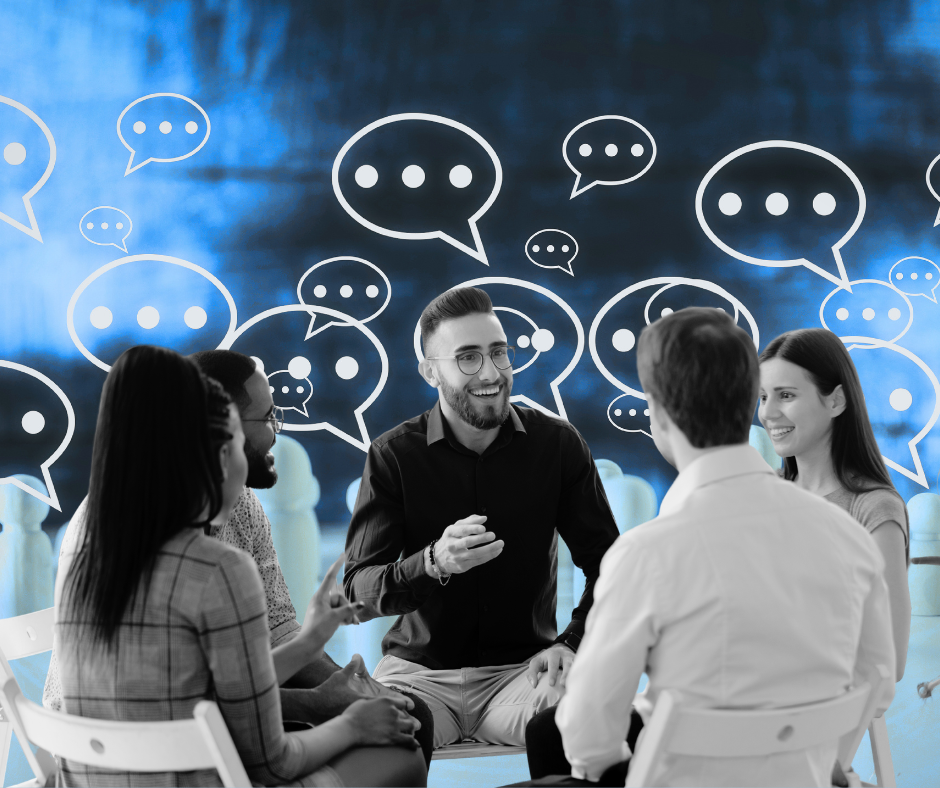 Employees sitting at a table, smiling and talking.