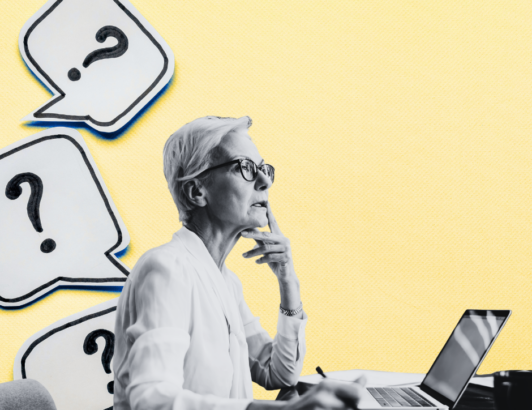 Woman sitting at a computer desk thinking about something.